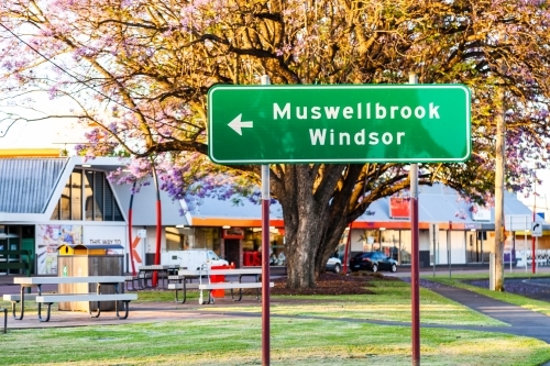 Green road direction sign in Singleton pointing towards Muswellbrook and Windsor - Australian Stock Image