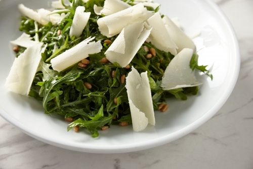 green salad mixed with nuts and shaved cheese