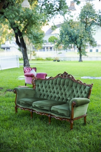 Green velvet couch in garden setting - Australian Stock Image