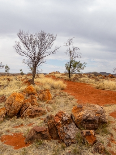 grey sky red dirt and rocky outcrop in Central Australia