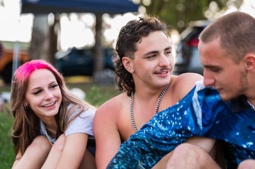 Group of Aussie teens sitting together together on a summer afternoon by a lake - Australian Stock Image