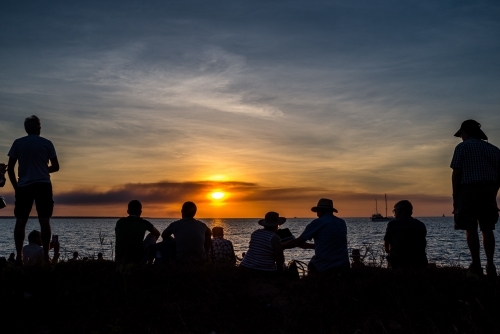 Group of people watching the sunset over the sea at Mindil Beach Markets in Darwin - Australian Stock Image