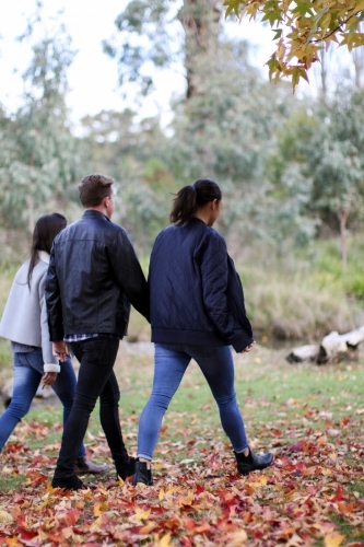 Group of young people walking in a rural environment in autumn - Australian Stock Image