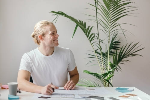 Guy at work looking sideways across the office studio - Australian Stock Image