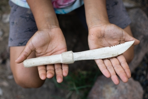 Hands holding hand carved wooden knife - Australian Stock Image