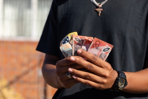 hands holding several banknotes - Australian Stock Image