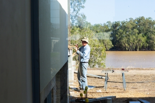 Handyman working outside seen through window