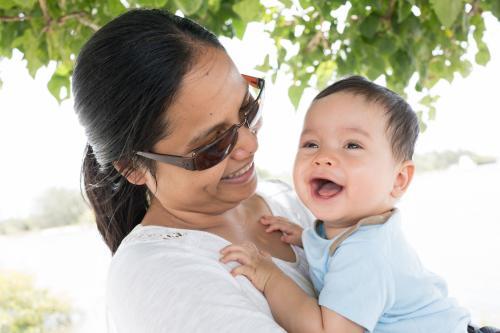 Happy Asian mum with her mixed race baby boy outside