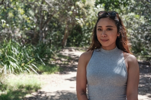 Happy Asian young adult woman in the park - Australian Stock Image