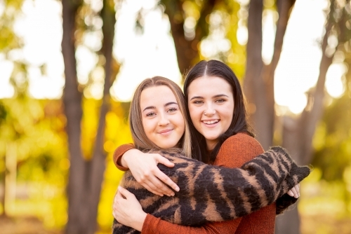 happy best friends with arms around each other - Australian Stock Image