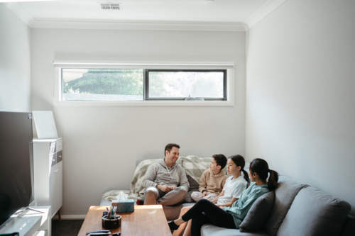 Happy family gathered in the entertainment room. - Australian Stock Image