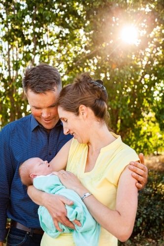 Happy little family with their newborn baby in arms - Australian Stock Image