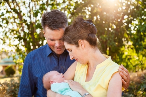 Happy little family with their newborn baby in arms - Australian Stock Image