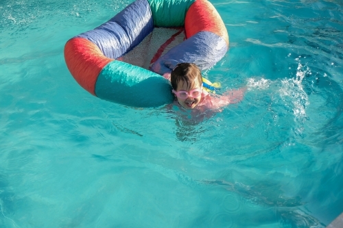 Happy little girl playing in the pool - Australian Stock Image