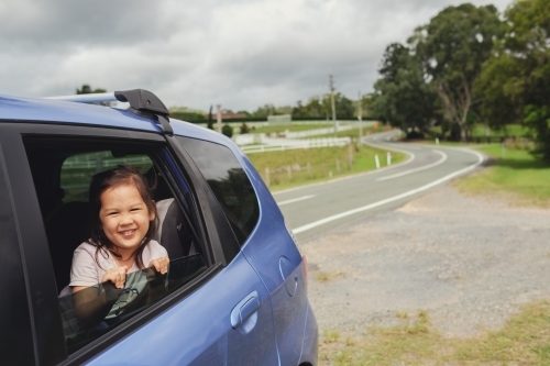 Happy little multiethnic girl on a road trip - Australian Stock Image