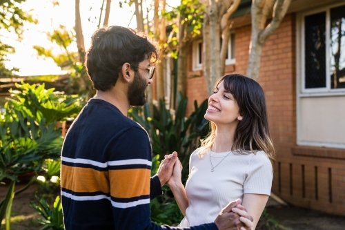 happy mixed race couple holding hands - Australian Stock Image