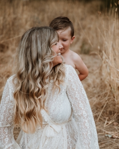 Happy mother and son together in field outside - Australian Stock Image