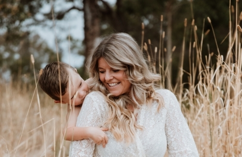 Happy mother and son together in field outside - Australian Stock Image