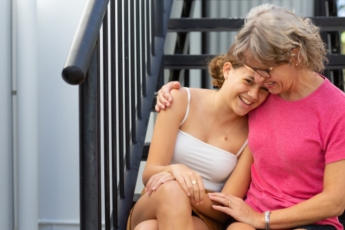 happy mother and teen daughter embracing - Australian Stock Image