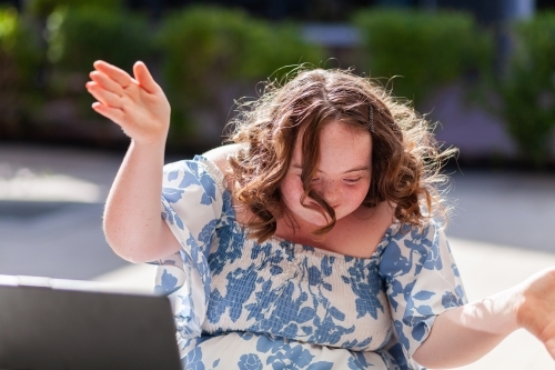 Happy seventeen year old girl with a disability doing a joyful dance move - Australian Stock Image