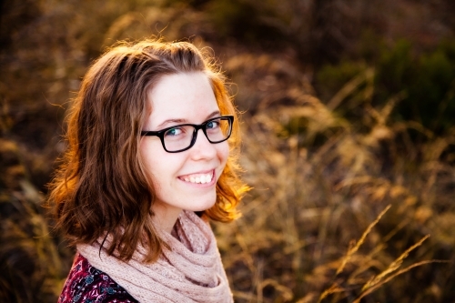 Happy teen girl smiling in golden sunset light outside - Australian Stock Image
