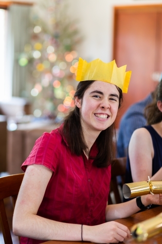 portrait of happy teen person smiling during Christmas lunch celebration - Australian Stock Image