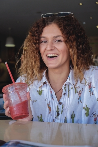 Happy teenage girl at juice bar - Australian Stock Image