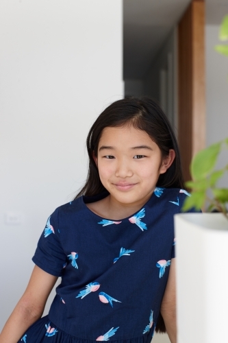 Happy young Japanese girl in kitchen - Australian Stock Image