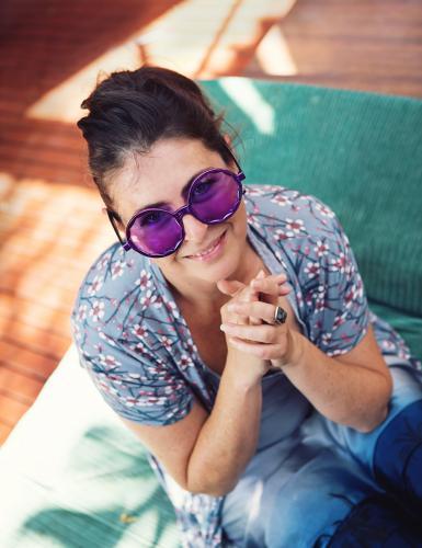 Happy young woman in dress up large purple costume sunglasses - Australian Stock Image