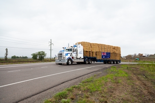 Hay Runners truck going through Singleton with bales of hay on the way to assist farmers in drought - Australian Stock Image