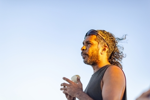 head and shoulders of aboriginal man in profile against blue sky