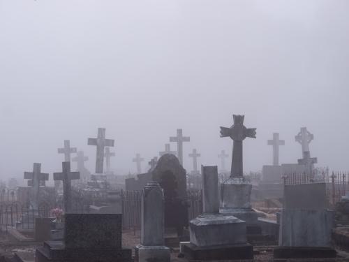 Headstones in a cemetery shrouded in mist - Australian Stock Image