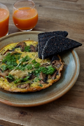 Healthy omelet dish and drinks on wooden table - Australian Stock Image