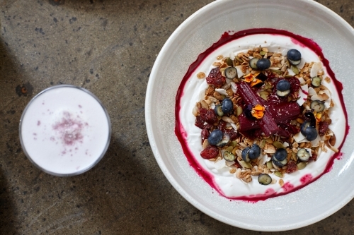 Healthy porridge served with hot beverage in vegetarian cafe - Australian Stock Image