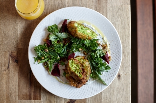 Healthy vegetarian falafel and salad dish on wooden table - Australian Stock Image