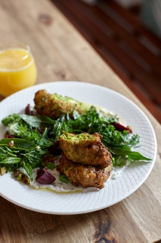 Healthy vegetarian falafel and salad dish on wooden table - Australian Stock Image