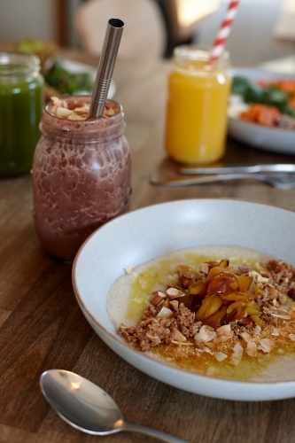 Healthy vegetarian smoothie and porridge on wooden table - Australian Stock Image