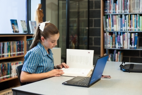 High school student working in a library - Australian Stock Image