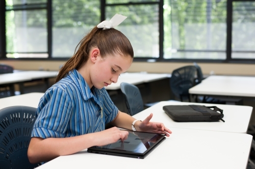 High School student working on a tablet in a classroom - Australian Stock Image