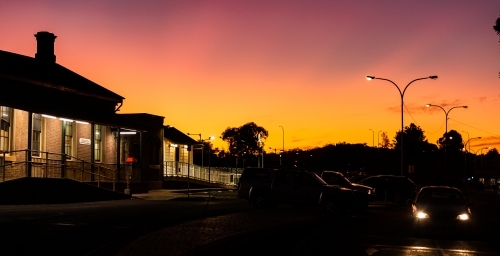 Horizontal image of train station at nightfall with cars leaving - Australian Stock Image