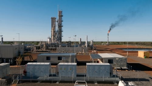 Horizontal photo of a power plant with a smoking flue-gas stack and cranes. - Australian Stock Image