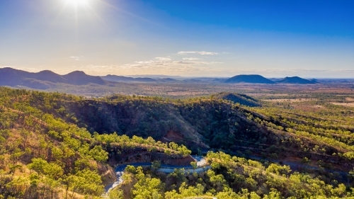 Horizontal photo of winding road in Mount Morgan with a steep road side with wild flowers and plants - Australian Stock Image