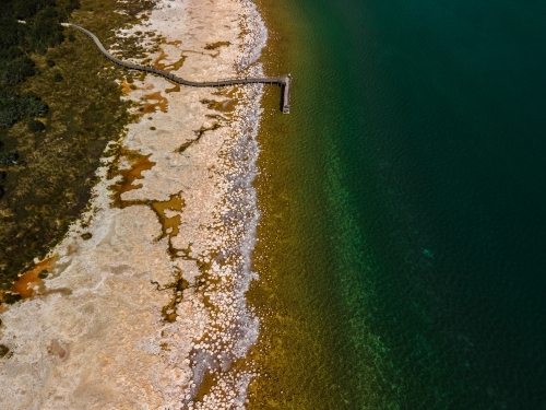 horizontal  shot of a beach walkway with bushes, trees and waves on a sunny day - Australian Stock Image