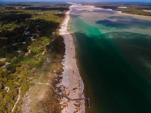 horizontal shot of a beach with long shoreline with bushes and trees - Australian Stock Image