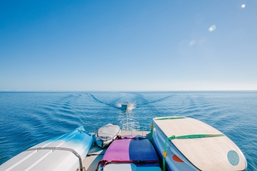 Horizontal shot of a boat with surfboards while towing another boat