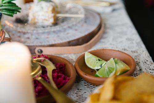 Horizontal shot of a bowl with lime and other side dishes on the table. - Australian Stock Image