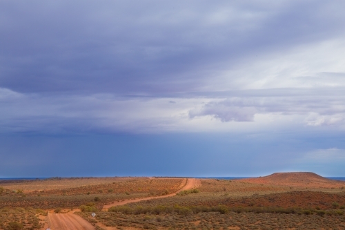 Horizontal shot of a dirt track through barren land - Australian Stock Image