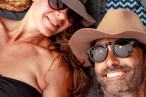 horizontal shot of a man and a woman both wearing sunglasses and hats - Australian Stock Image