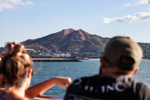 horizontal shot of a mountain with ocean view and a man and woman in the foreground - Australian Stock Image