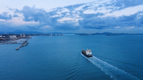 Horizontal shot of a port and a ship sailing - Australian Stock Image